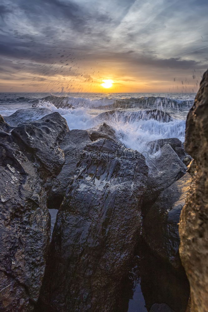 Similar – Sea crashes light waves into rocky bay, long exposure