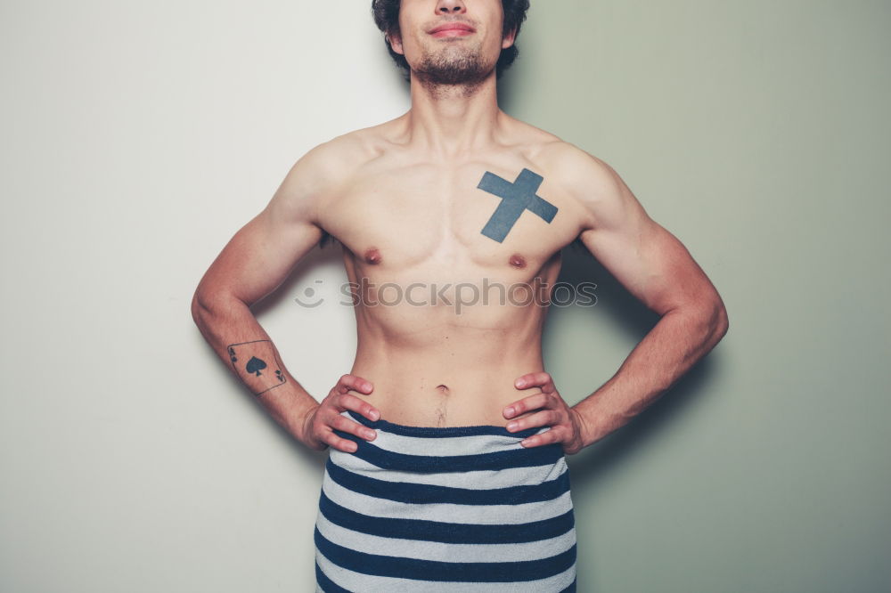 Image, Stock Photo young man spreads his arms like an angel while leaning against the wall with a tattoo on his bare chest