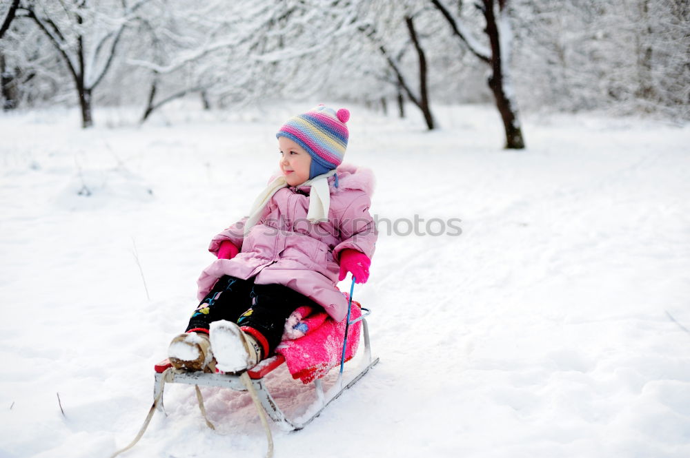 Similar – A woman pulls a sled through the snow. Winter atmosphere.