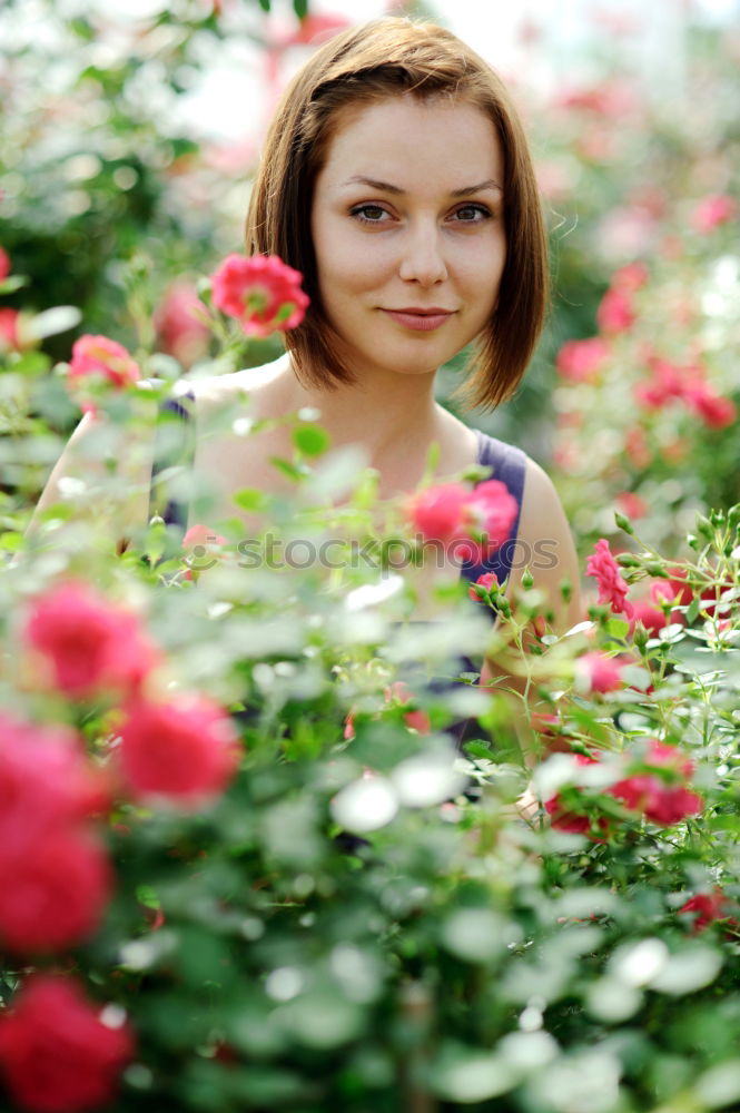 Similar – Redhead woman smelling a flower in a park