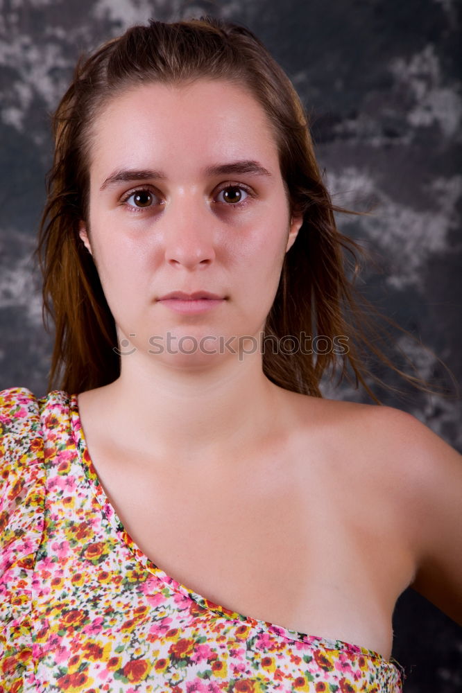 Foto Bild Reife, hübsche, moderne, schöne, elegante Frau mit tief ausgeschnittenem Dekollete vom Blumenkleid, steht im Urlaub, im Schatten vom Hauseingang und schaut müde, traurig, besorgt, übernächtigt in die Kamera. Die Sonnenbrille, ist auf dem Kopf.