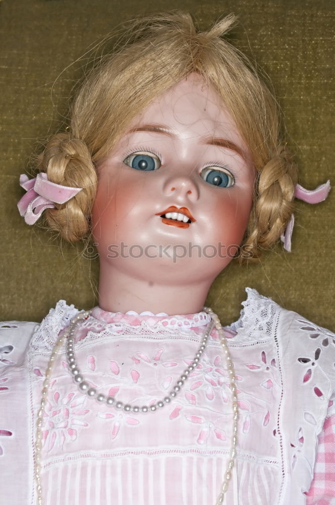 old doll with pigtails and a stare