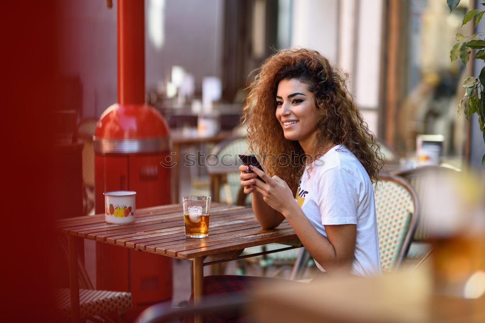 Image, Stock Photo Girl sitting in a street bar looking at her smartphone