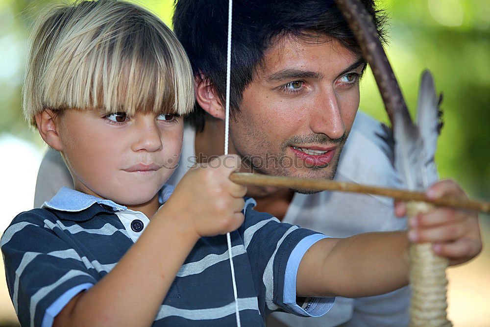 Similar – Image, Stock Photo Cheerful young man teaching his son to play mini golf