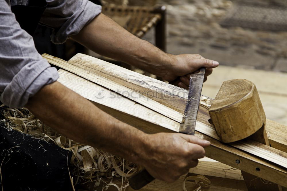 Similar – Carpenter with circular saw cutting a wooden plank