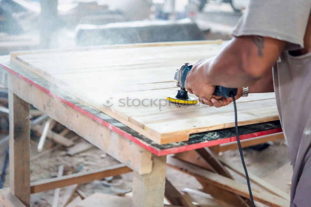 Similar – Carpenter cutting wooden board