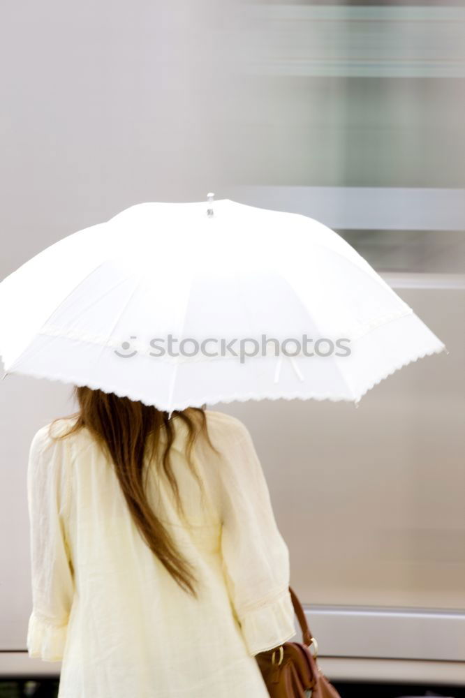 Similar – Woman with umbrella in front of green wall