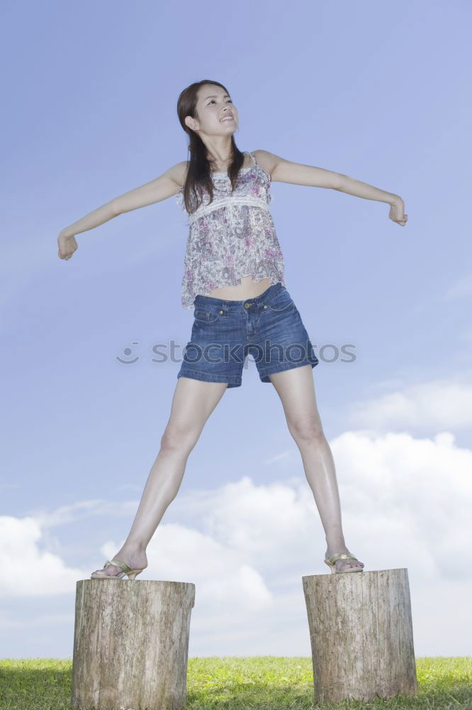 Similar – Girl with sunglasses, short jeans and long legs, jumps happily in summer, happily up on the trampoline, with blue sky in the background.