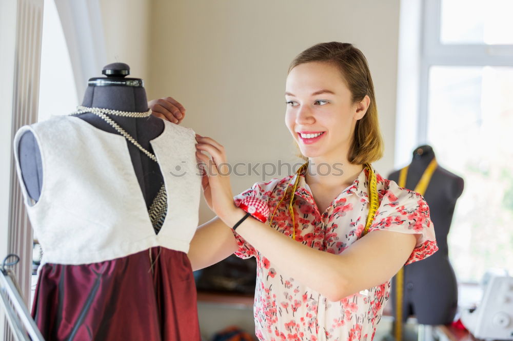 Similar – Young woman hanging clothes on coat hanger