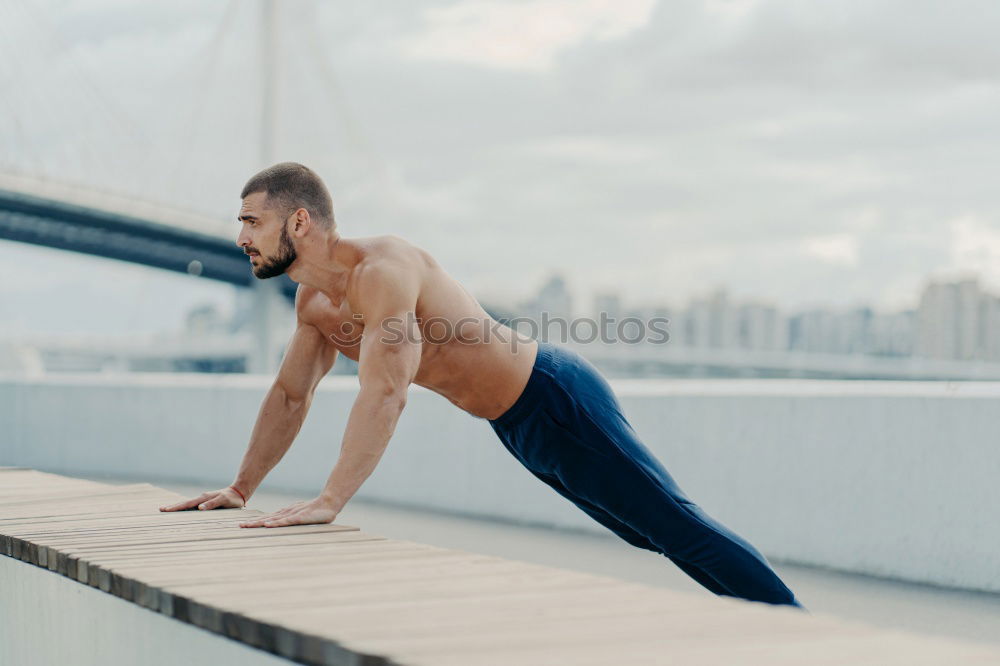 Similar – Seitenschuss eines muskulösen Mannes macht umgekehrte Push-up-Übung, trainiert die Arme, hält perfekten Körper und gute körperliche Form, trainiert aktiv im Freien, trägt Sporthosen und Turnschuhe, posiert auf der Brücke