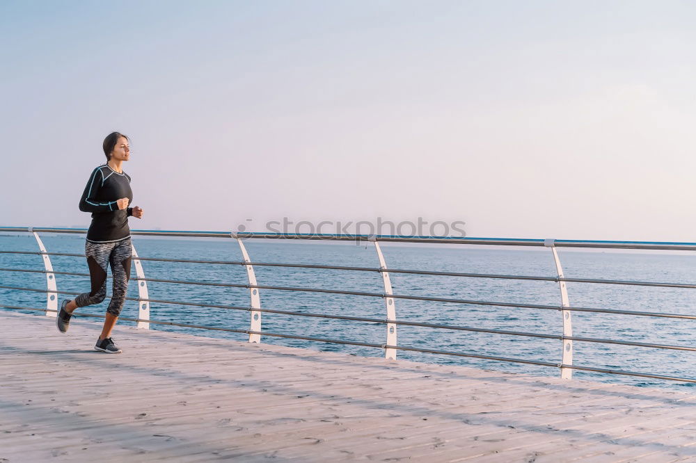 Similar – Young fitness woman runner running on city bridge.