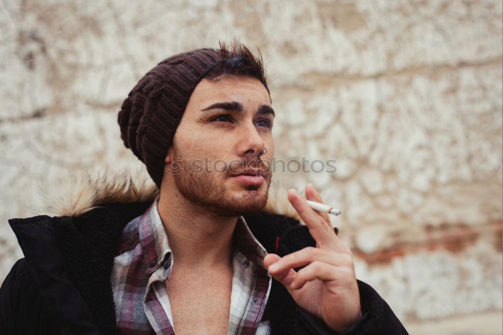 Similar – Young bearded man in urban background wearing casual clothes while leaning on a wall and looking at camera