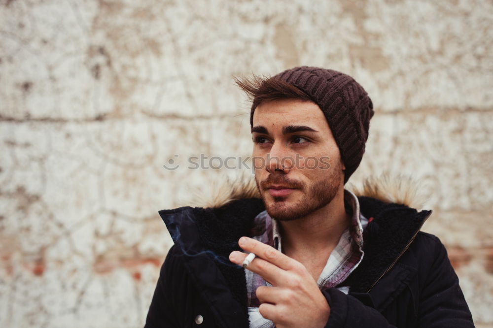 Similar – Young bearded man in urban background wearing casual clothes while leaning on a wall and looking at camera