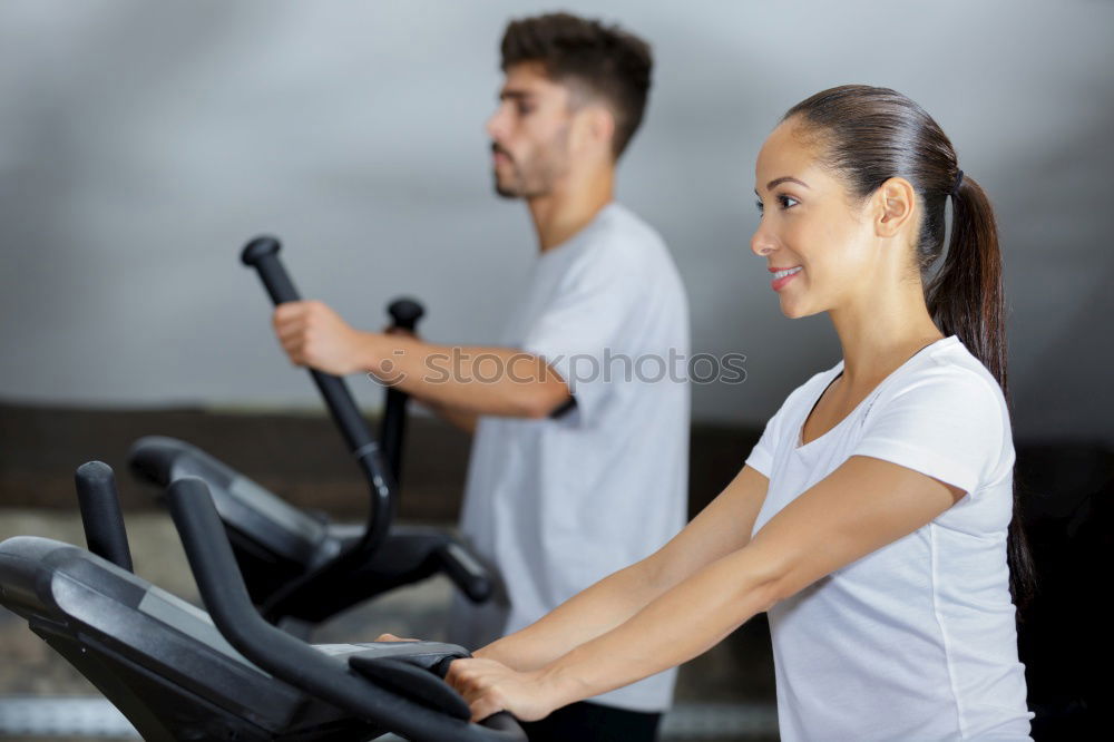 Similar – Image, Stock Photo Two people biking in the gym, exercising legs doing cardio workout cycling bikes