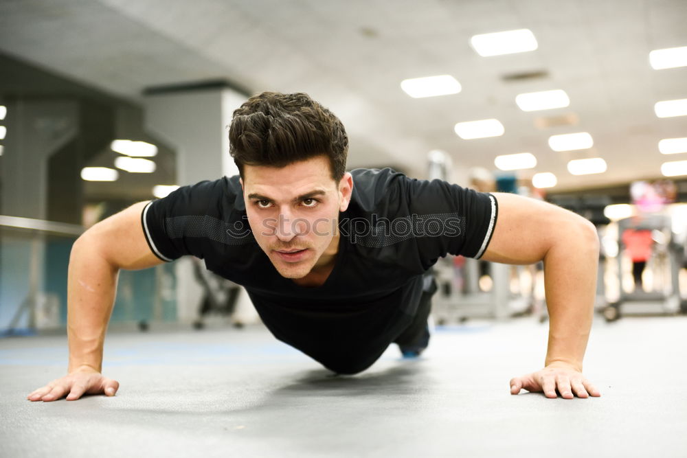 Attractive man doing pushups in the gym.