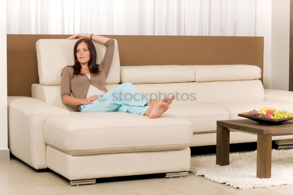 Similar – young, tall, leggy woman sits barefoot on a light couch