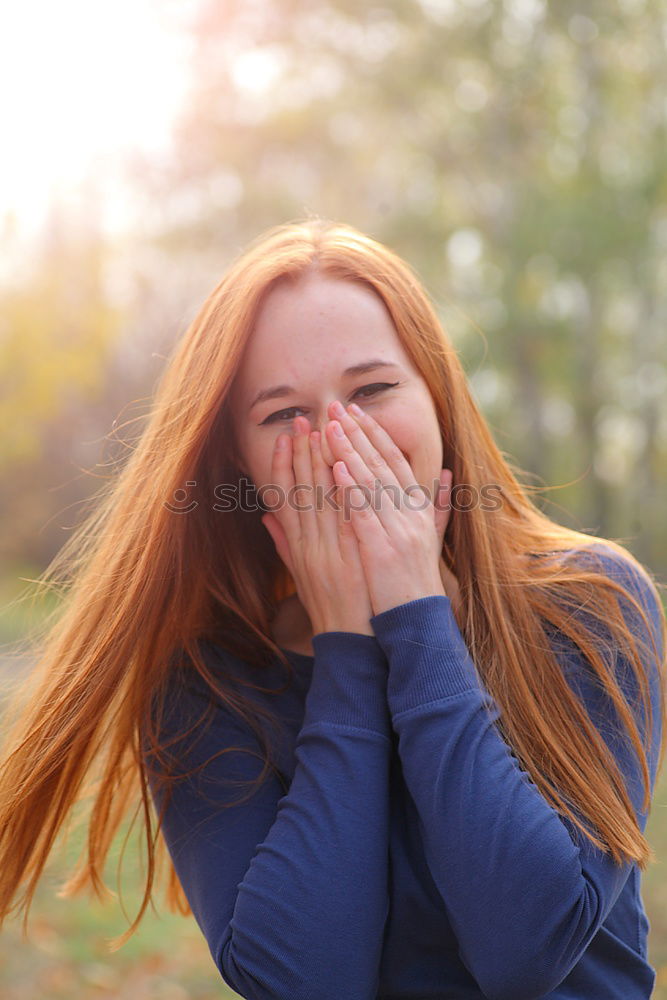 Similar – Woman with long red curly hair laughs looking at camera while holding a hand in front of her mouth