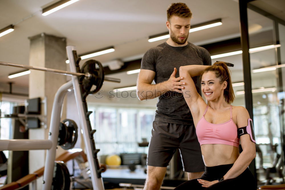 Similar – Personal trainer helping young woman lift weights