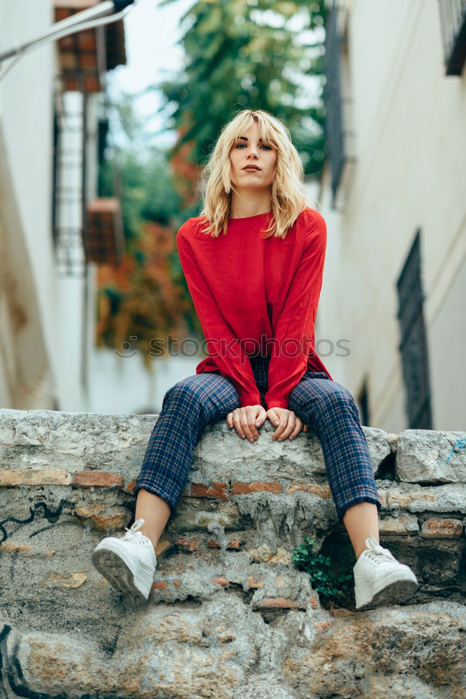 Blonde girl with red shirt enjoying life outdoors.