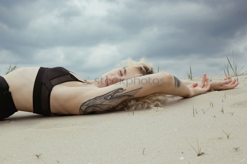 Similar – Young woman with turquoise hair sits barefoot in beach forest leaning against tree and looks skeptically at camera