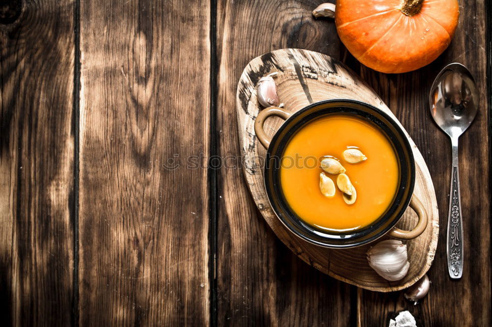 female hands holding an iron mug with carrot juice