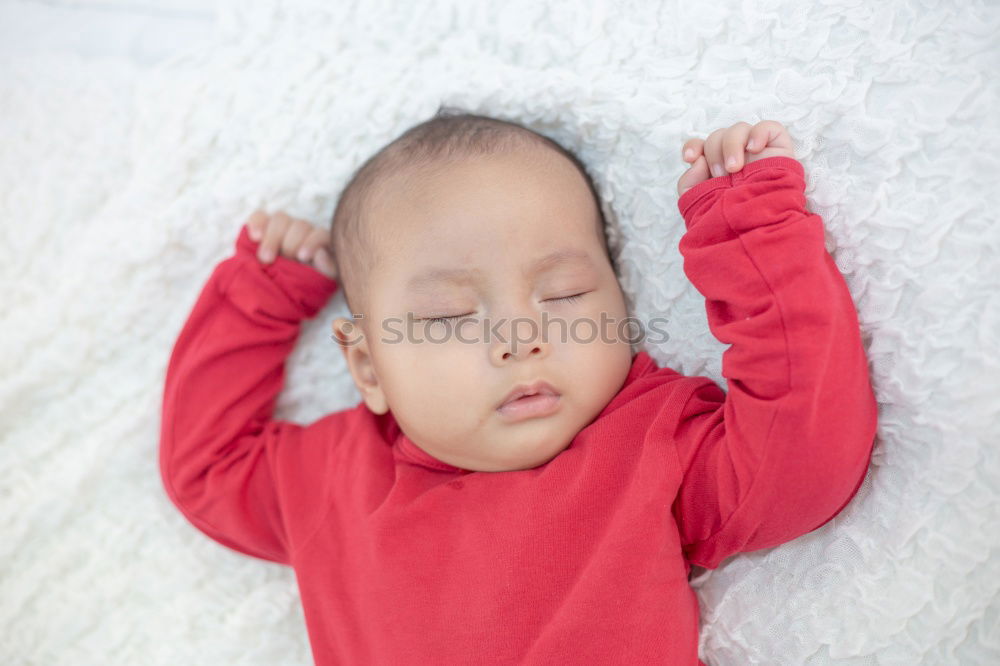 Similar – Adorable baby sleeping wrapped in a red blanket