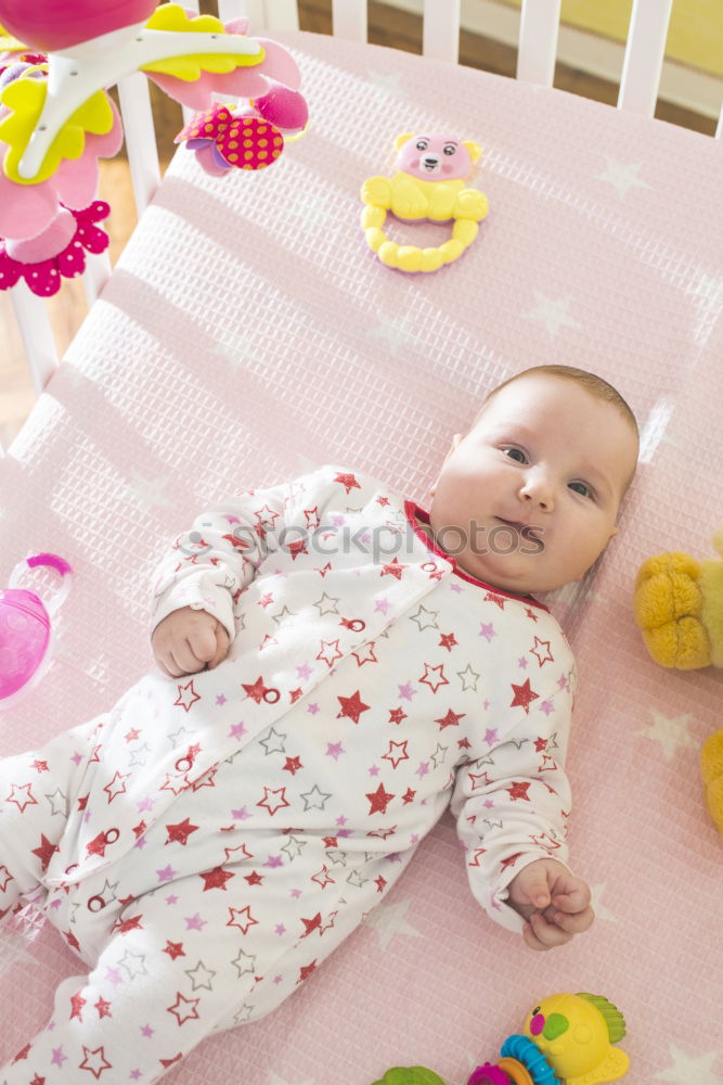 Similar – Baby girl in a bed with toys around.