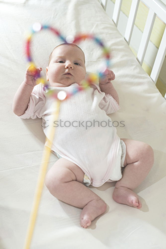 Baby in a bed in frame of heart shape. Out of focus baby