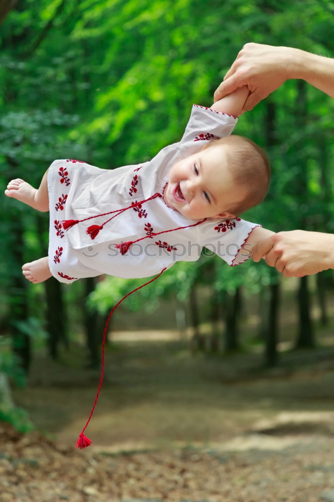 Mother holding kid on hands in park