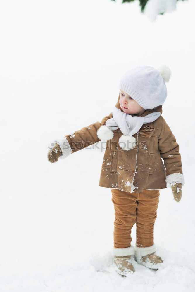 Similar – Image, Stock Photo Happy little girl enjoying snow. Child playing outdoors walking through deep snow in wintertime while snow falling. Toddler is wearing dark blue snowsuit