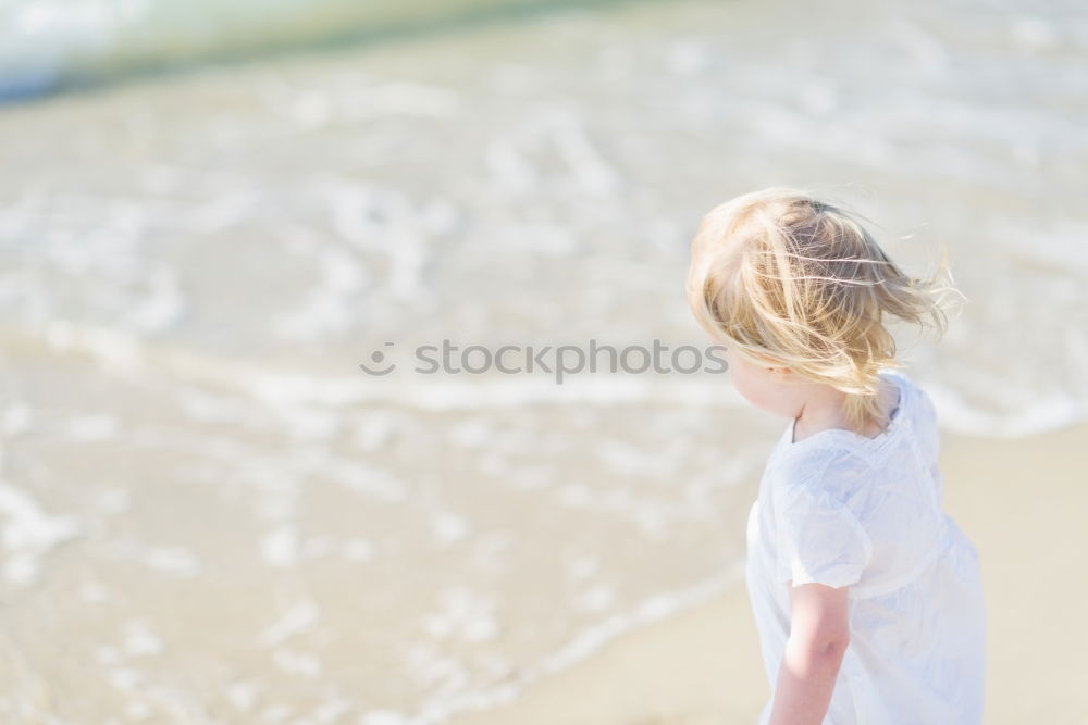 Similar – Child sitting by the sea with a view of a jetty