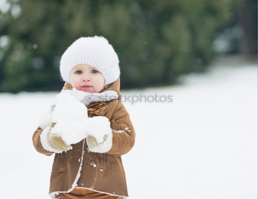 Similar – baby girl in knitted hat walking in winter forest