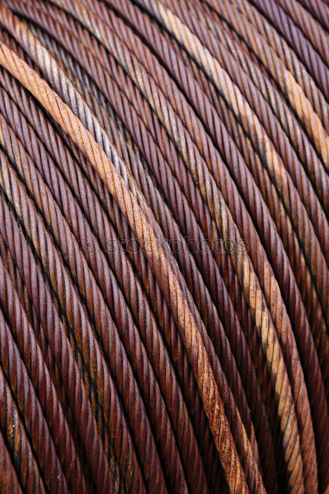 Rusty iron pipes wrapped with steel cable