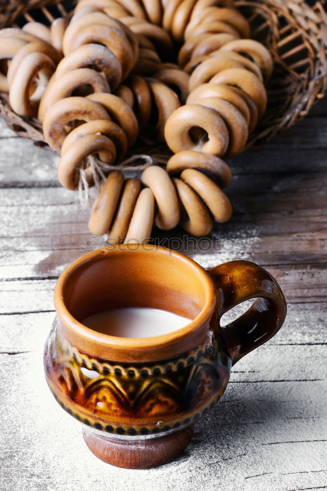 Cup of coffee on old wooden table with kitchen towel