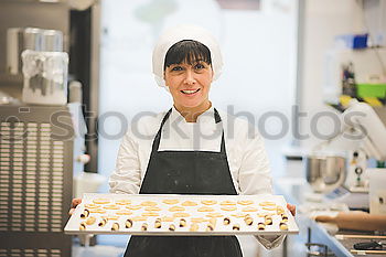 Similar – A cook in a restaurant wearing a mask as a precaution against the coronavirus preparing the meal.