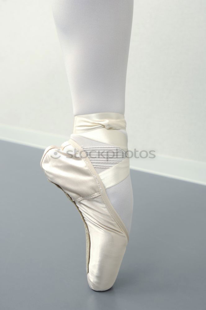 Similar – Ballerina laces up her pointe shoes