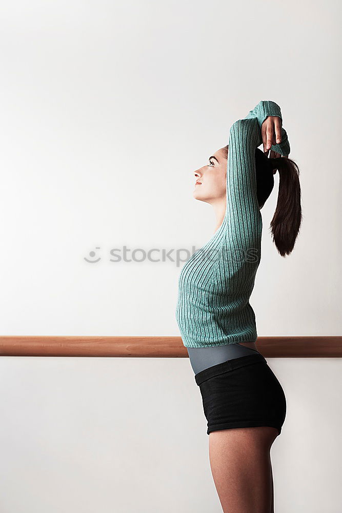 Similar – young, red-haired woman stands barefoot in front of the window and leans against the ceiling beams