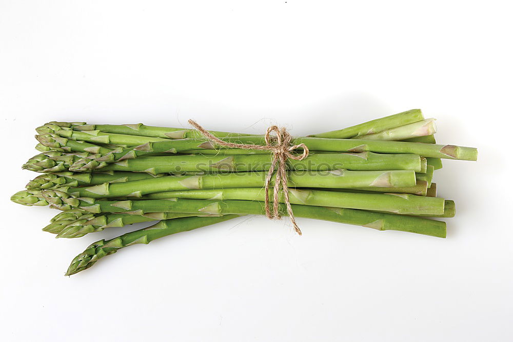 Similar – Image, Stock Photo A portion of green asparagus, freshly harvested from the local field, decorated with a plaid ribbon of cloth, tied together, lies in the light on the table, on a white cloth of linen.