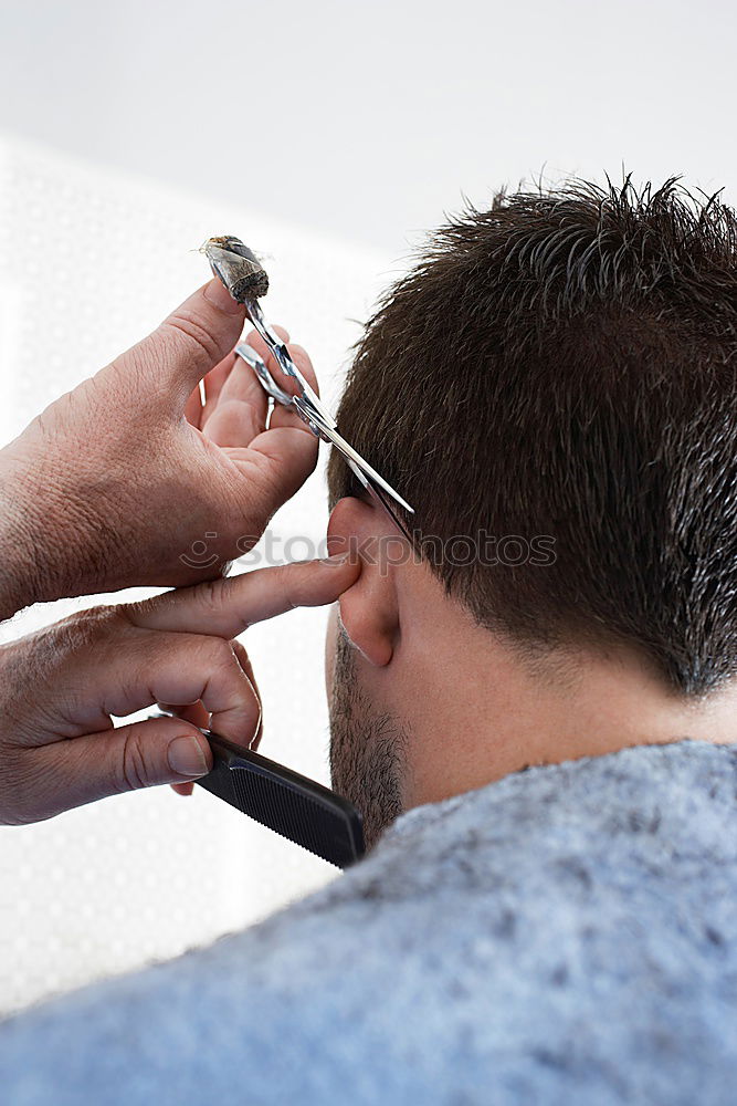 Foto Bild Detail der Hände eines Friseurs, der einem Kunden mit einem Rasiermesser die Haare schneidet