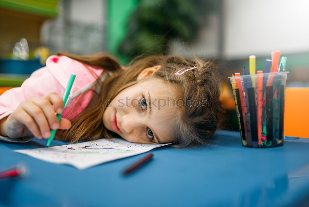 Similar – Thoughtful girl writing in class