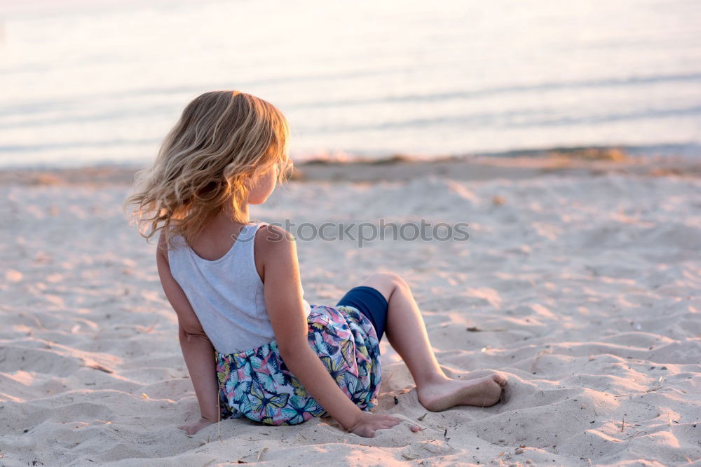 Similar – Child sitting by the sea with a view of a jetty