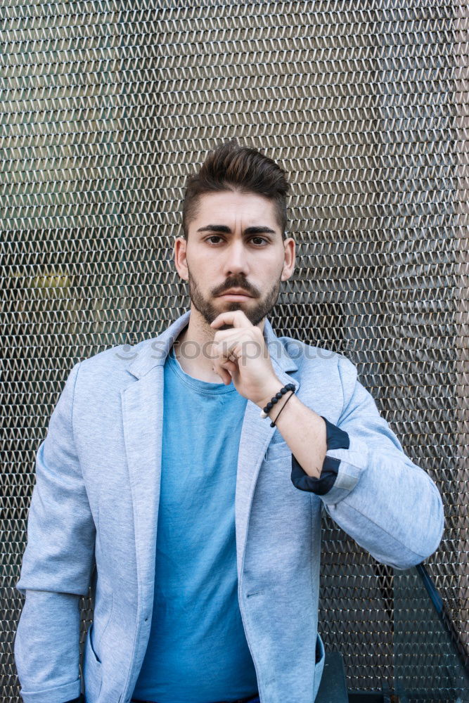 Similar – Young bearded man, model of fashion, in urban background wearing casual clothes while leaning on a wall and looking aside