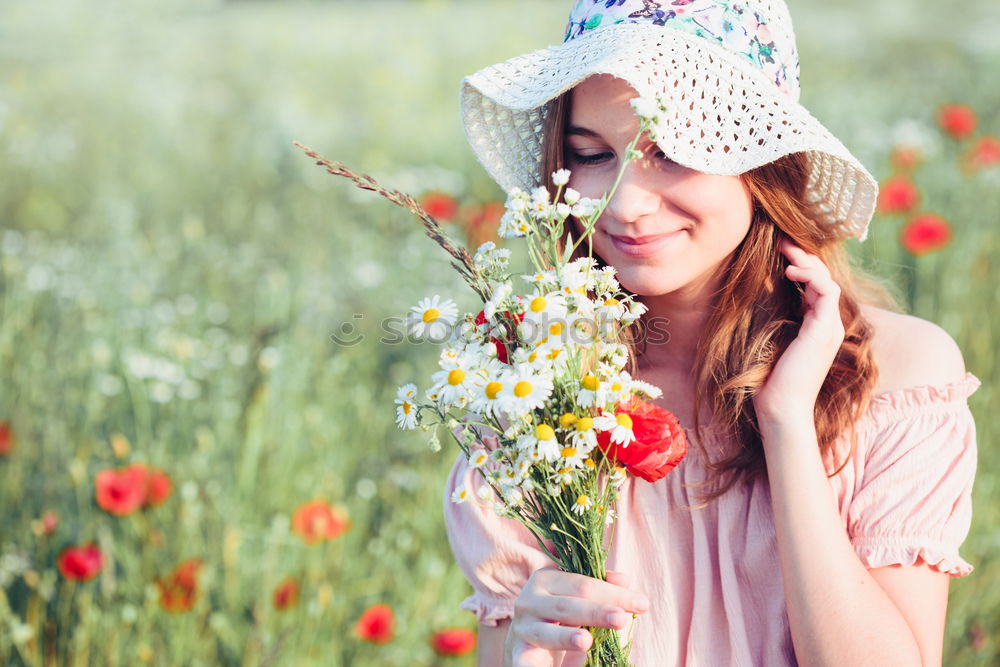 Beautieful young girl in the field of wild flowers