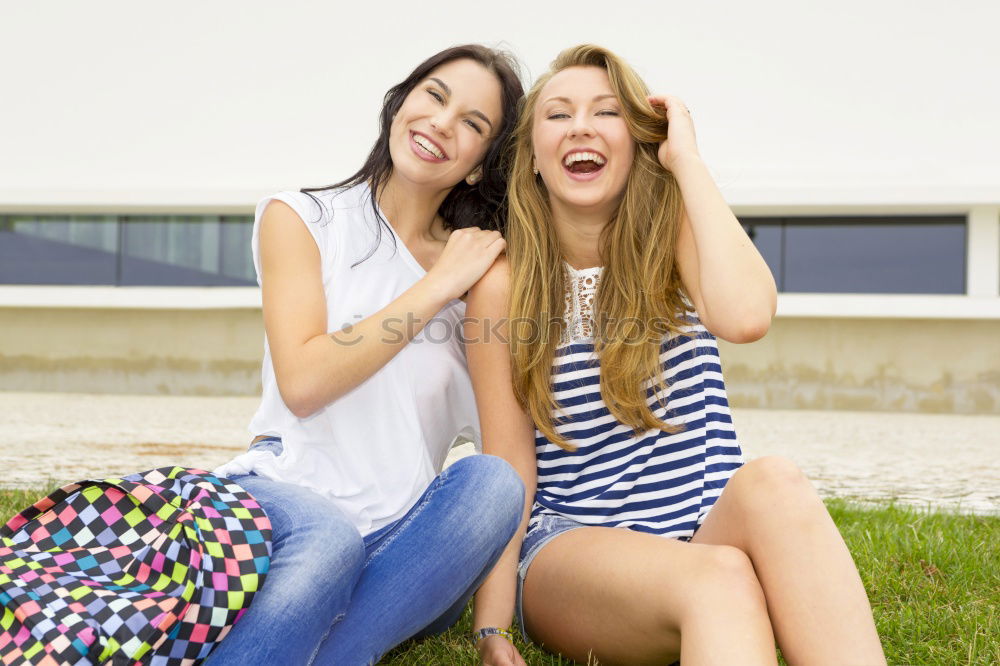 Similar – Two happy young women friends hugging in the street.