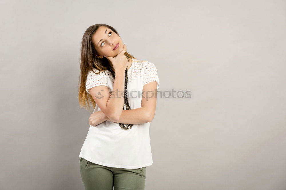 Young smiling blond woman leaning against wall