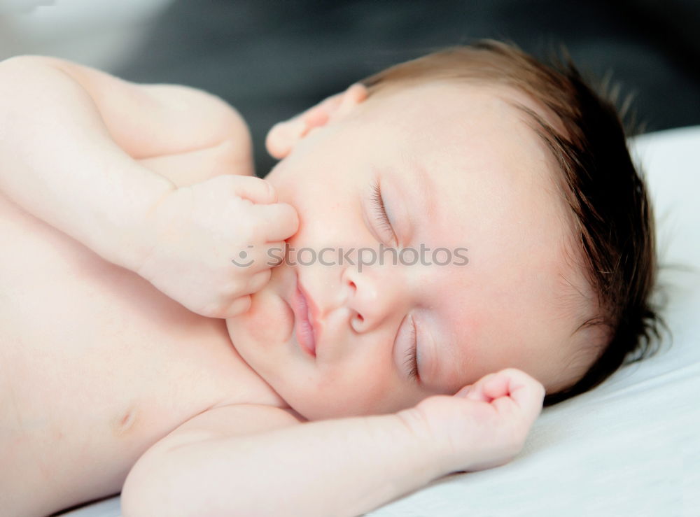 Similar – Newborn baby sleeping lying on blanket on the bed