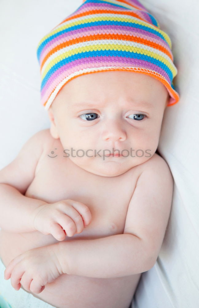 Baby with a colourful headscarf and blue eyes