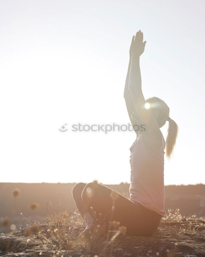 Similar – Agile young woman doing a handstand outdoors in the countryside balancing on her hands with her legs bent in opposite directions