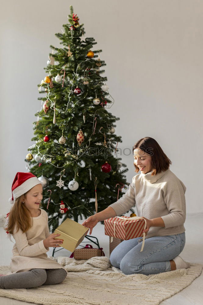 Similar – Young girl and her little sister decorating Christmas tree