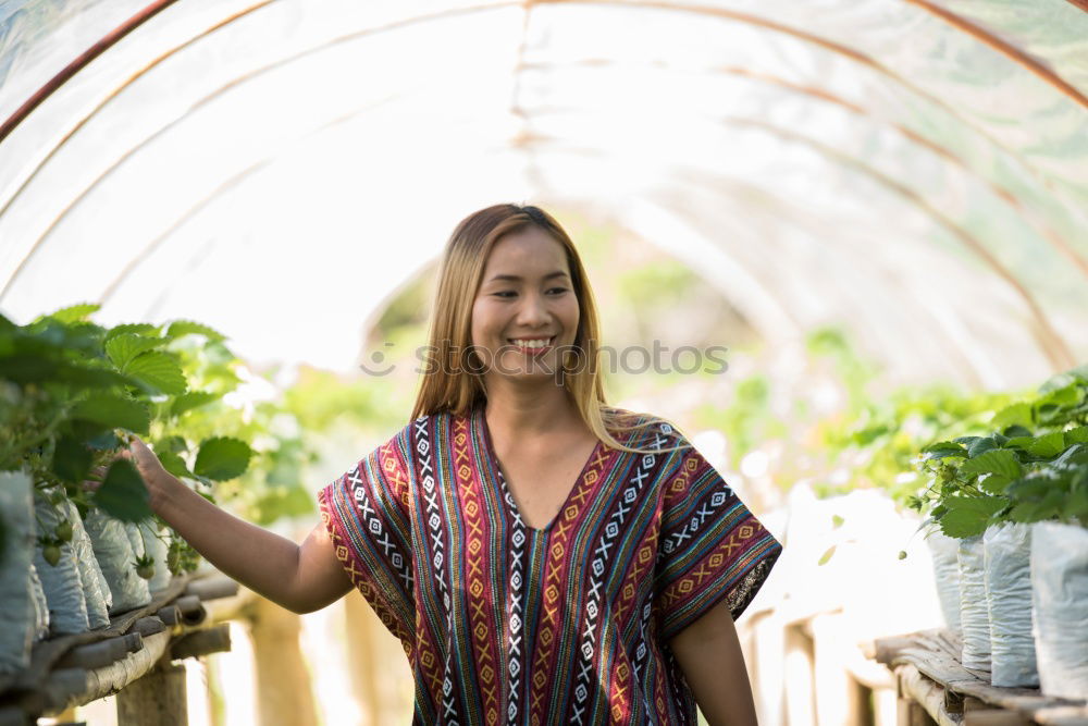 Similar – Image, Stock Photo Happy young woman farmer with wheelbarrow working in the greenhouse collecting vegetables. working in back yard, sunny nature. Funny rural collecting.